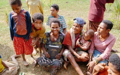 A Tay woman holding the Tay New Testament posing with others